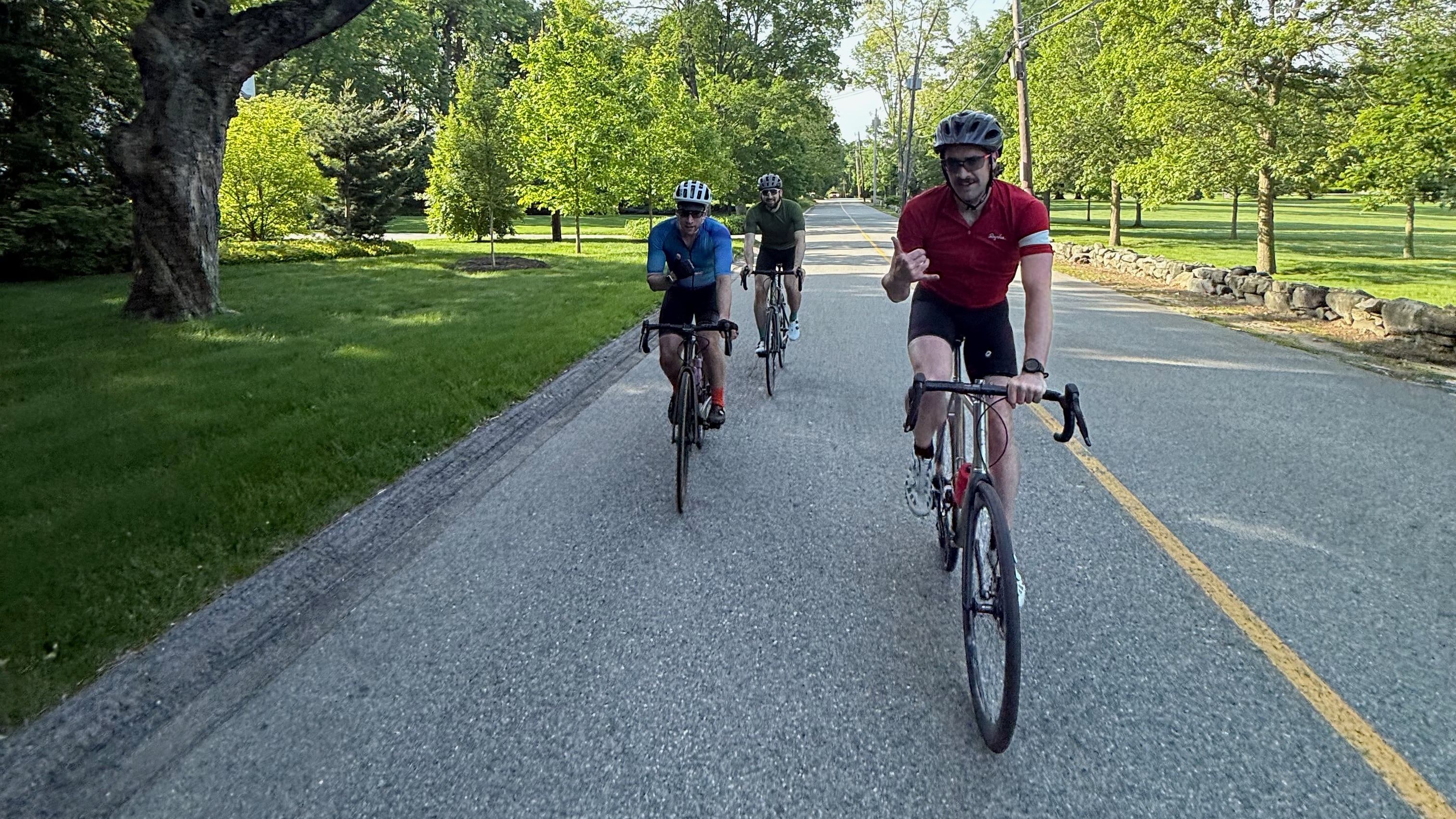A civilized group of road bike riders coming on Lincoln center on a beautiful sumemer morning